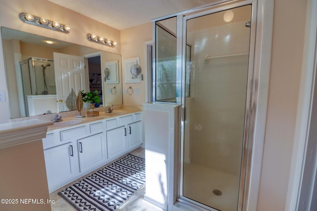 bathroom featuring vanity, an enclosed shower, tile patterned flooring, and a textured ceiling