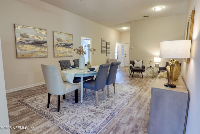 dining area featuring hardwood / wood-style flooring and a textured ceiling