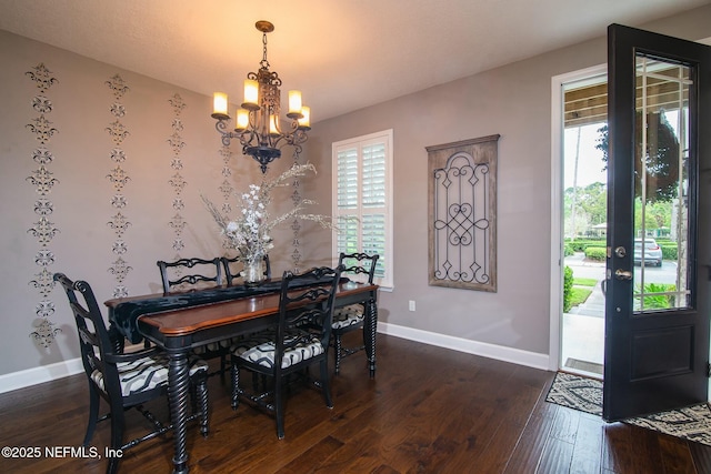 dining room with dark wood-type flooring, plenty of natural light, and a chandelier