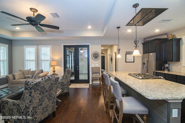 kitchen with hanging light fixtures, a kitchen island, appliances with stainless steel finishes, and a kitchen breakfast bar