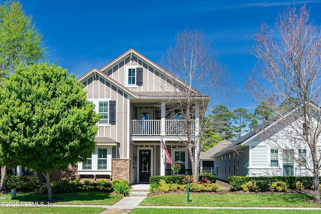 view of front of home featuring a front yard and a balcony