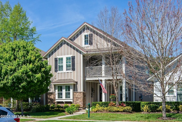 view of front of property featuring a front lawn and a balcony