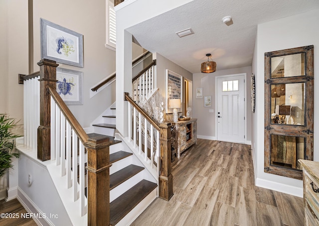 foyer with hardwood / wood-style flooring and a textured ceiling