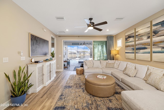 living room with ceiling fan and light hardwood / wood-style floors