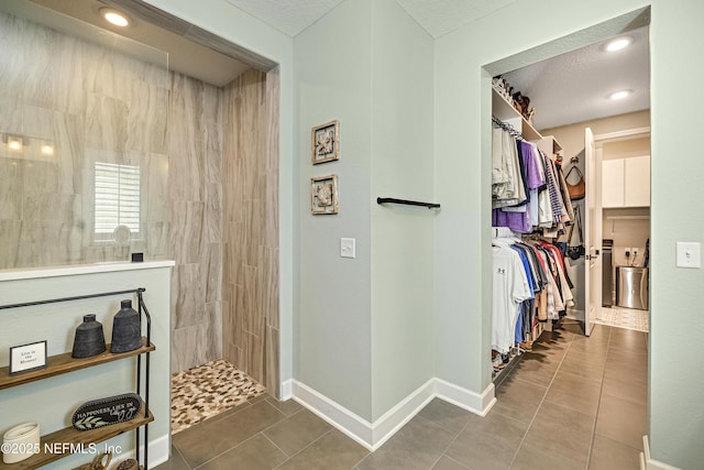 hall featuring tile patterned floors and a textured ceiling