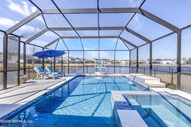 view of pool with pool water feature, a water view, glass enclosure, an in ground hot tub, and a patio