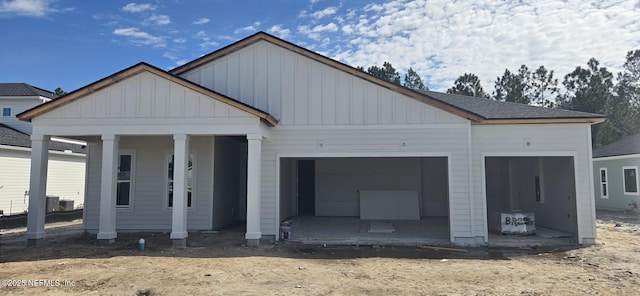 view of front facade with a garage, board and batten siding, driveway, and a shingled roof