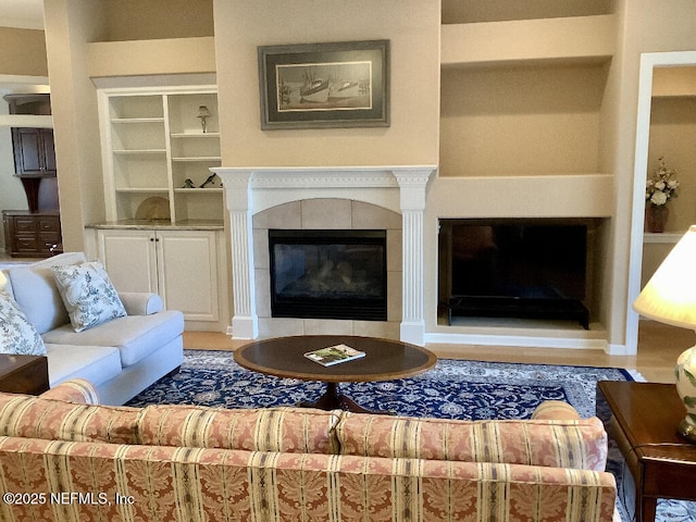 living room with built in shelves and a fireplace