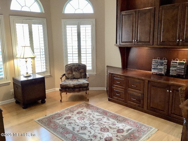 living area featuring light wood-type flooring and baseboards