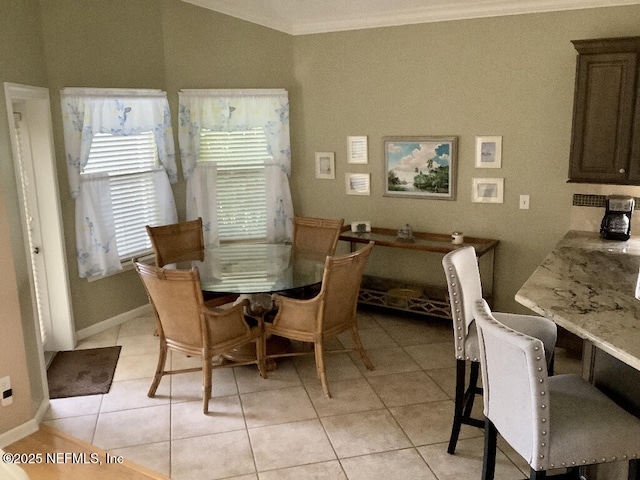 dining area with light tile patterned flooring, crown molding, and baseboards