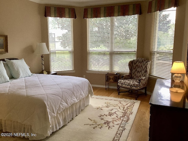 bedroom with baseboards and wood finished floors