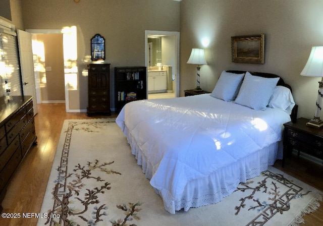 bedroom with wood finished floors and ensuite bathroom