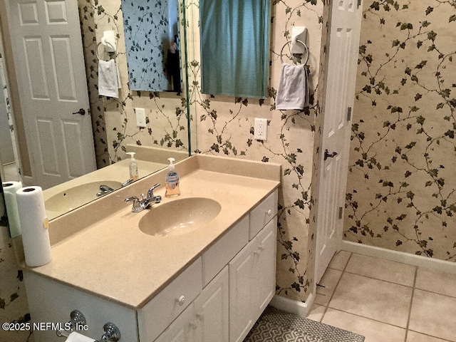 bathroom with tile patterned flooring, vanity, baseboards, and wallpapered walls