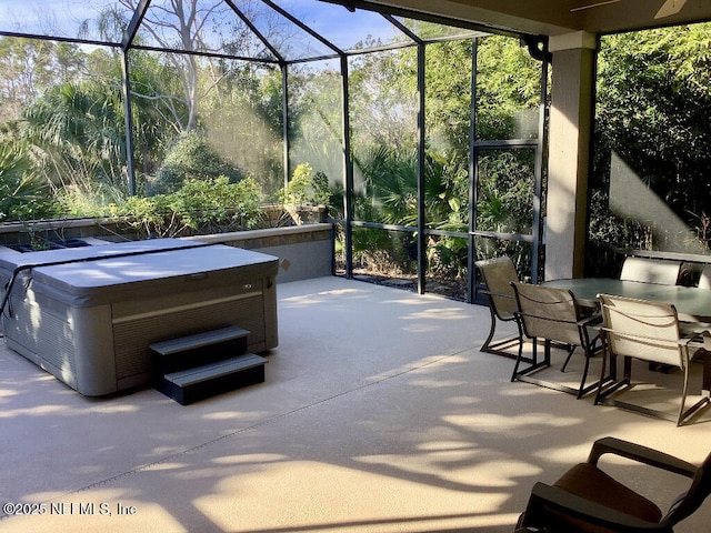 view of patio / terrace featuring outdoor dining area, glass enclosure, and a hot tub