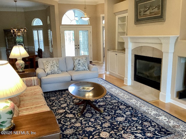 tiled living room with built in features, french doors, and a fireplace