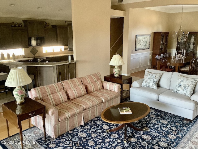 living area with a decorative wall, crown molding, and wainscoting