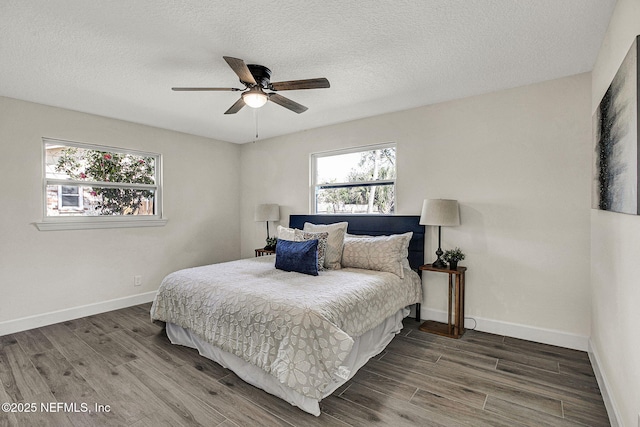 bedroom featuring ceiling fan, hardwood / wood-style floors, and a textured ceiling