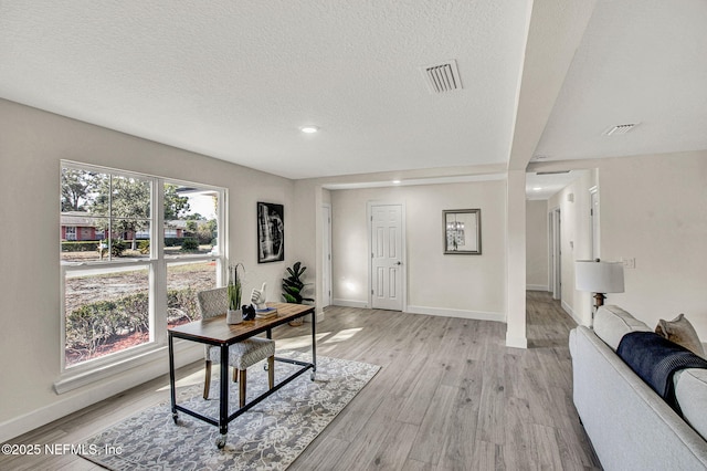 office area featuring a textured ceiling and light wood-type flooring