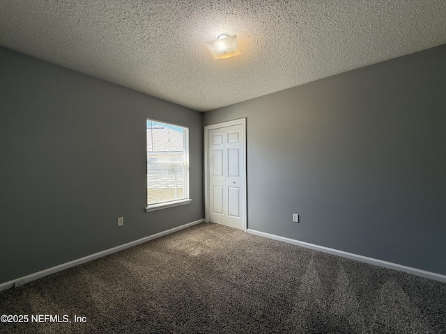 carpeted spare room with a textured ceiling