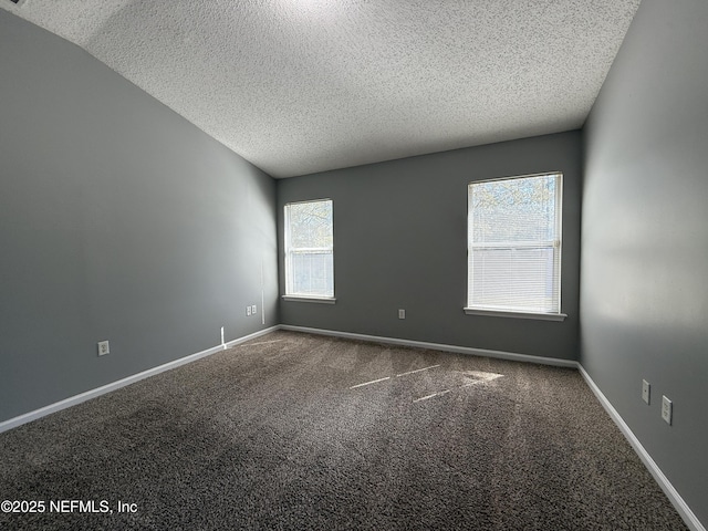 carpeted empty room with a textured ceiling