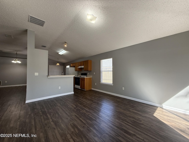 unfurnished living room featuring dark hardwood / wood-style floors, a chandelier, vaulted ceiling, and a textured ceiling