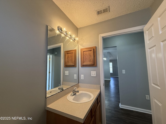 bathroom featuring vanity, hardwood / wood-style floors, and a textured ceiling