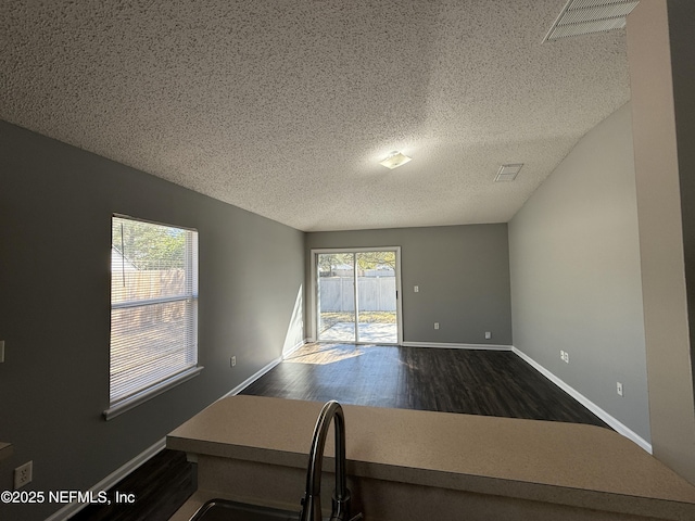 empty room featuring dark wood-type flooring and a textured ceiling