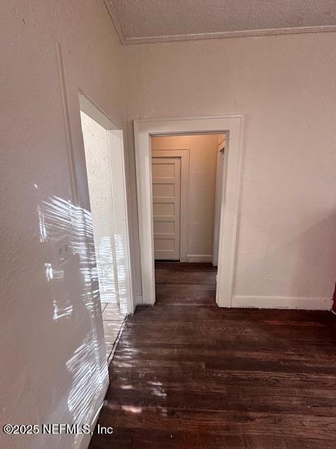 hall with dark wood-type flooring and a textured ceiling