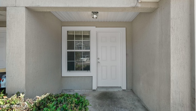 view of exterior entry with stucco siding