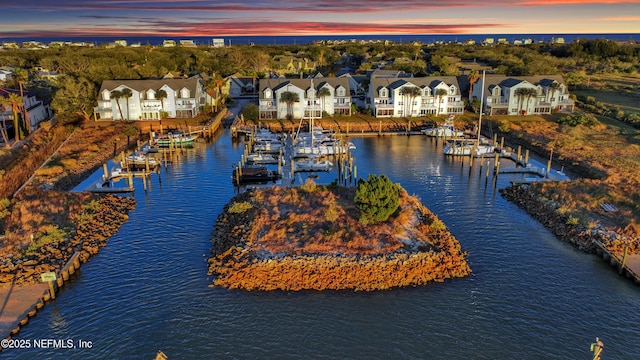 aerial view at dusk featuring a water view