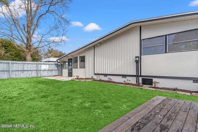 view of side of property featuring a lawn and a deck