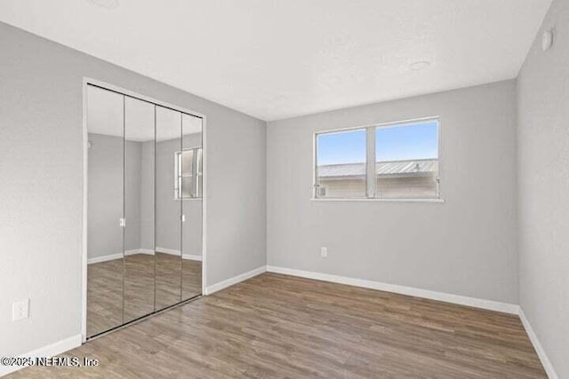 unfurnished bedroom featuring hardwood / wood-style floors and a closet