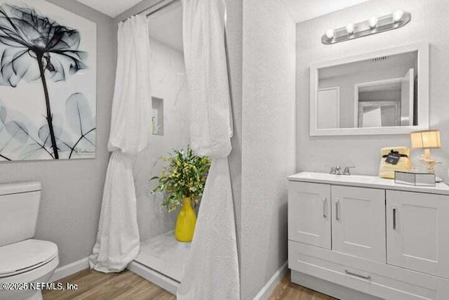 bathroom featuring vanity, hardwood / wood-style floors, and toilet