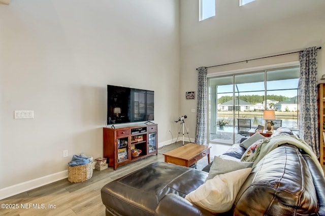 85248 Berryessa Way, Fernandina Beach, FL 32034 - living room featuring a towering ceiling, light hardwood / wood-style floors, and a wealth of natural light