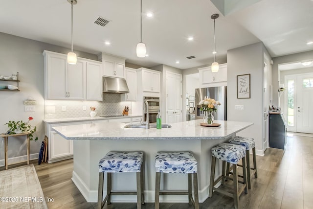 85248 Berryessa Way, Fernandina Beach, FL 32034 - kitchen with a kitchen island with sink, hanging light fixtures, stainless steel appliances, and white cabinets