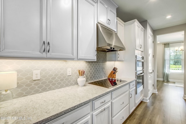 85248 Berryessa Way, Fernandina Beach, FL 32034 - kitchen with hardwood / wood-style floors, white cabinetry, backsplash, black electric stovetop, and stainless steel double oven
