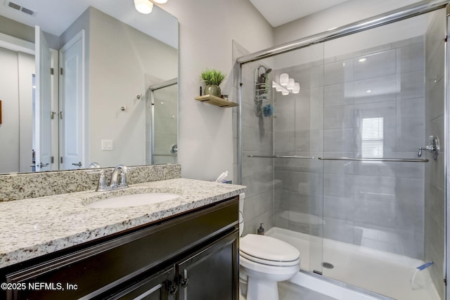85248 Berryessa Way, Fernandina Beach, FL 32034 - bathroom featuring vanity, a shower with shower door, and toilet