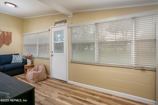 interior space with hardwood / wood-style flooring, crown molding, a wealth of natural light, and beamed ceiling