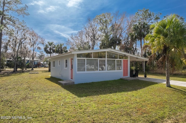 view of front of property with a carport and a front lawn