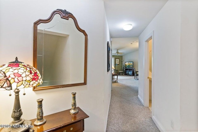 corridor featuring light colored carpet and vaulted ceiling