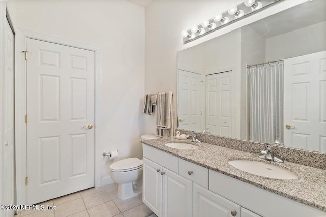 bathroom featuring vanity, tile patterned floors, and toilet