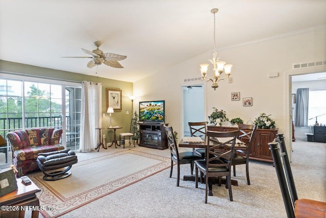 dining room featuring lofted ceiling, ceiling fan with notable chandelier, and light carpet