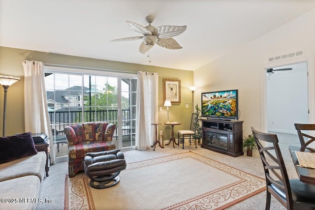 living room featuring vaulted ceiling, ceiling fan, and carpet flooring