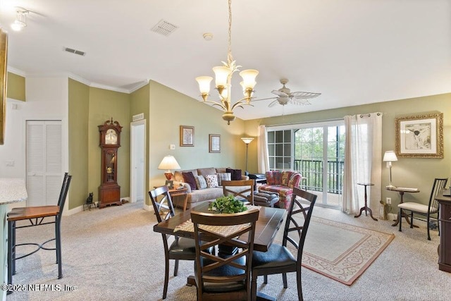 dining area with crown molding, ceiling fan with notable chandelier, and light colored carpet