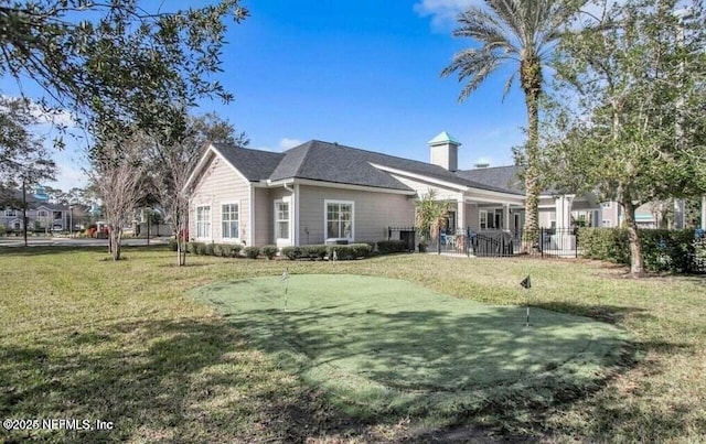 rear view of house featuring a yard