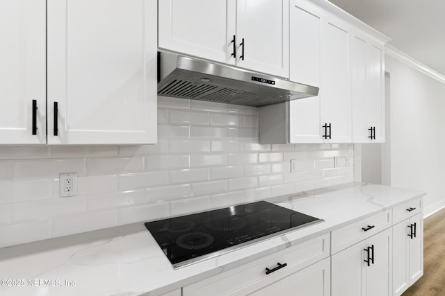 85034 Southern Creek Blvd, Fernandina Beach, FL 32034 - kitchen with light hardwood / wood-style flooring, black electric stovetop, light stone countertops, white cabinets, and decorative backsplash