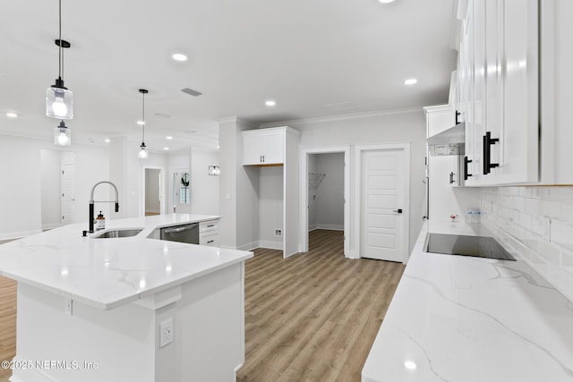 85034 Southern Creek Blvd, Fernandina Beach, FL 32034 - kitchen featuring decorative light fixtures, sink, white cabinets, black electric stovetop, and a center island with sink