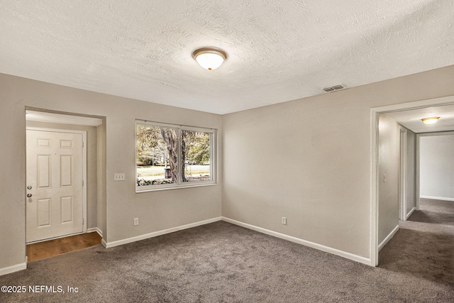 carpeted spare room with a textured ceiling