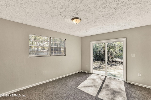 carpeted spare room featuring a textured ceiling