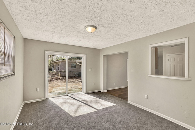 unfurnished room featuring dark carpet and a textured ceiling